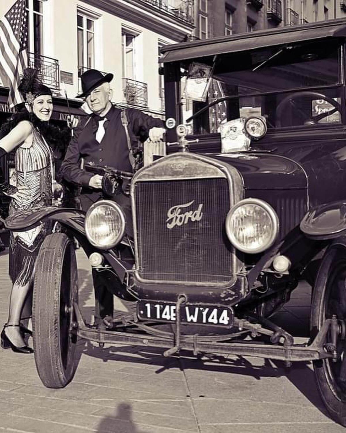 Couple en tenue années folles devant une Ford ancienne devant L'Univers Café - ambiance prohibition années 1930